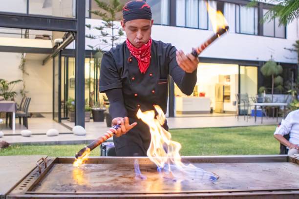 Chef preparing Japanese food on the grill doing a preformance with fire