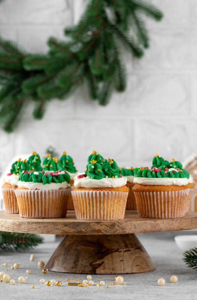 istock Christmas tree and wreath shaped cupcakes with candy sprinkles on top. Christmas dessert on a light concrete background. 2181956773
