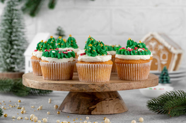 istock Christmas tree and wreath shaped cupcakes with candy sprinkles on top. Christmas dessert on a light concrete background. 2181956785