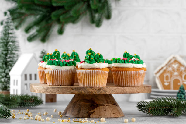 istock Christmas tree and wreath shaped cupcakes with candy sprinkles on top. Christmas dessert on a light concrete background. 2181956789