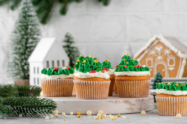 istock Christmas tree and wreath shaped cupcakes with candy sprinkles on top. Christmas dessert on a light concrete background. 2181956803