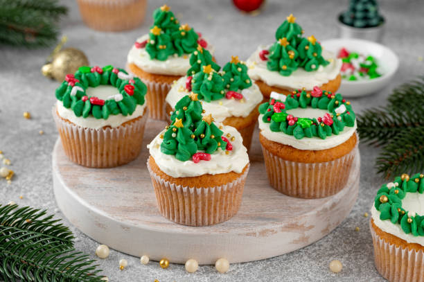 istock Christmas tree and wreath shaped cupcakes with candy sprinkles on top. Christmas dessert on a light concrete background. 2181956804