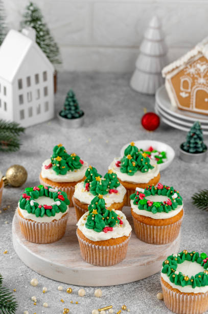 istock Christmas tree and wreath shaped cupcakes with candy sprinkles on top. Christmas dessert on a light concrete background. 2181956818