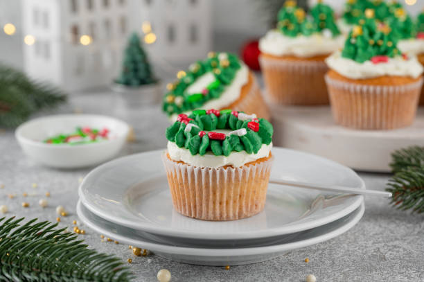 istock Christmas tree and wreath shaped cupcakes with candy sprinkles on top. Christmas dessert on a light concrete background. 2181956827