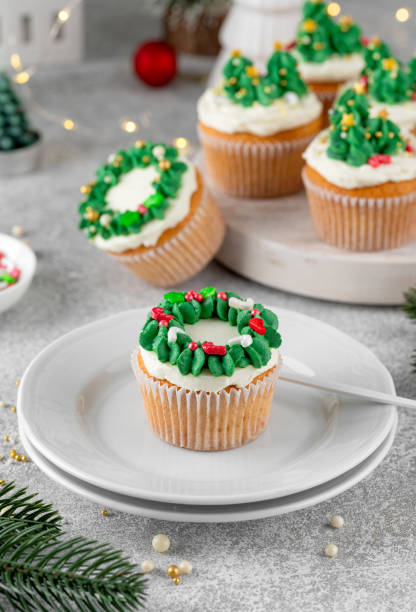 istock Christmas tree and wreath shaped cupcakes with candy sprinkles on top. Christmas dessert on a light concrete background. 2181956836