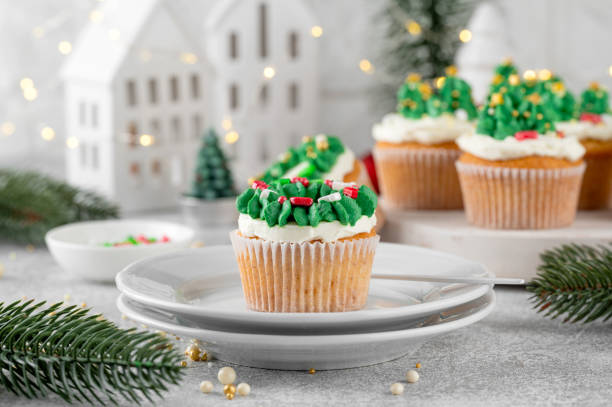 istock Christmas tree and wreath shaped cupcakes with candy sprinkles on top. Christmas dessert on a light concrete background. 2181956854