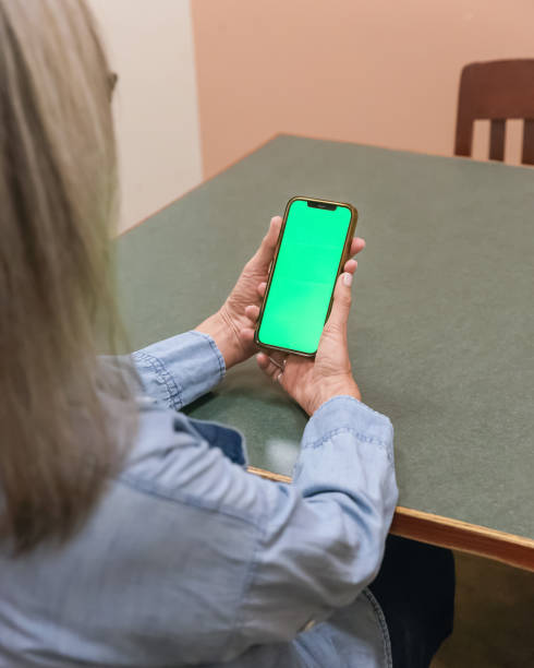 istock Woman holding phone with a green screen 2181958388