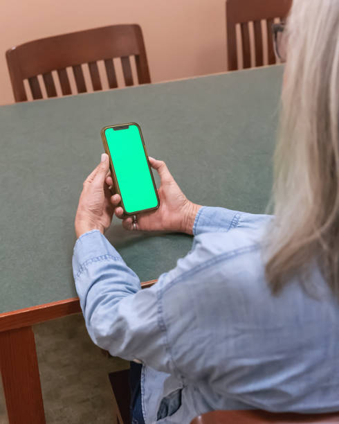 istock Woman holding phone with a green screen 2181958392
