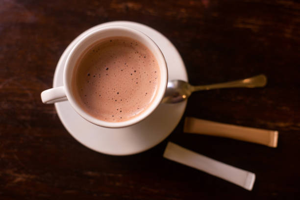 The Asian boy is stirring hot chocolate milk with stirring stick