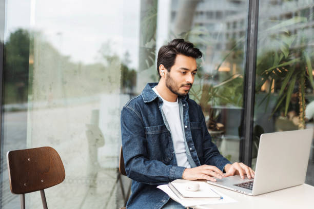 istock Focused freelancer working remotely on laptop in cafe 2181963736