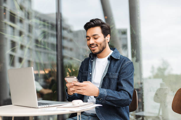 istock Freelancer working remotely using laptop and smartphone at outdoor cafe 2181963754