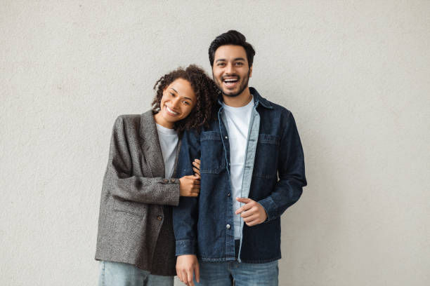 Happy multiracial couple smiling and embracing on white background