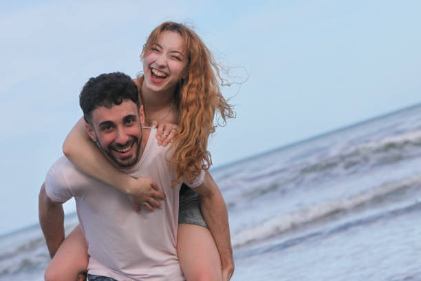 istock cheerful young couple on the beach 2181966694