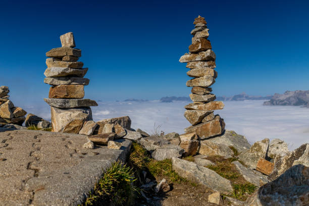 Stone pyramid in the mountains on the summit and ountain pass marking the trail