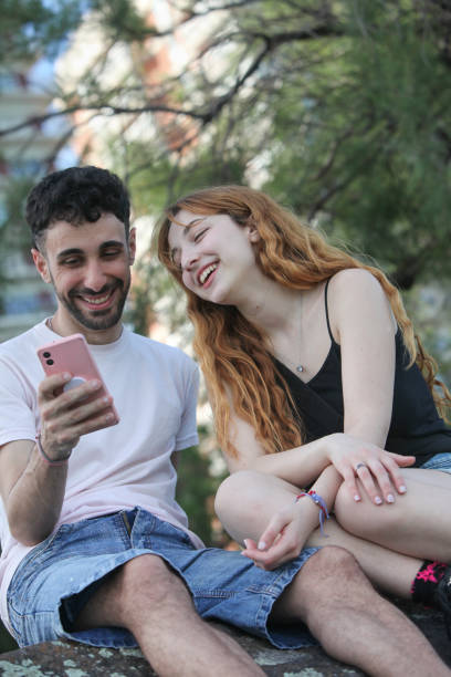 istock young happy couple with smartphone at the park 2181967384