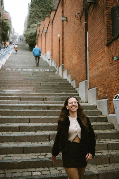 istock Young woman walking down a staircase 2181969503