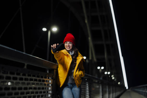 istock Young woman taking a selfie by her smart phone on the bridge 2181969657