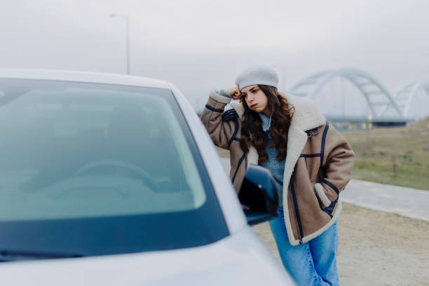 istock Angry woman using phone and standing by car 2181969856