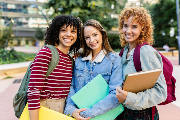 istock Three young university female students smiling together at camera on campus 2181970757