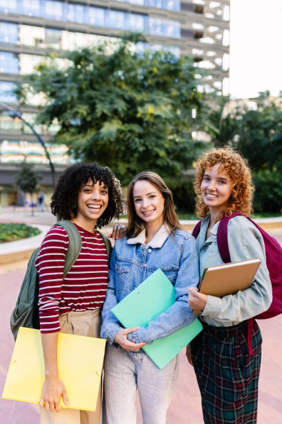 istock Three young university female students smiling together at camera on campus 2181970786