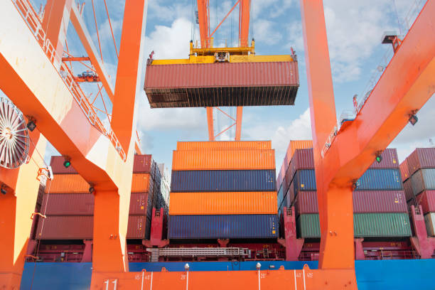 Crane lifting up container and loading truck in a port.