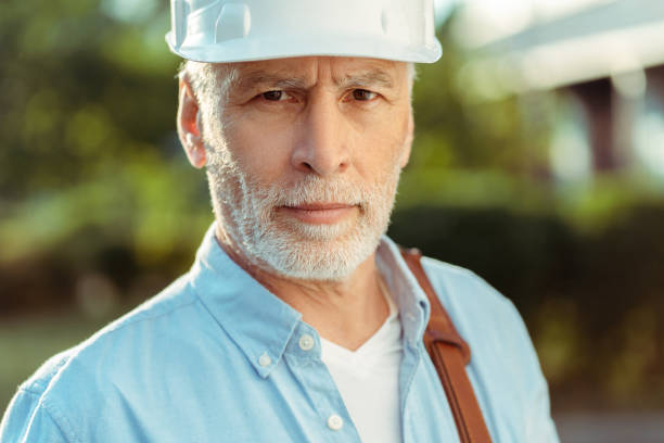 istock Senior engineer wearing white hard hat and carrying bag over shoulder 2181971410