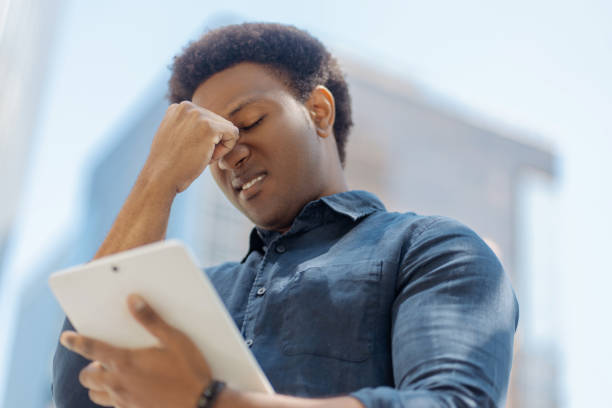 istock Stressed young professional experiencing headache while reading bad news on tablet 2181975245