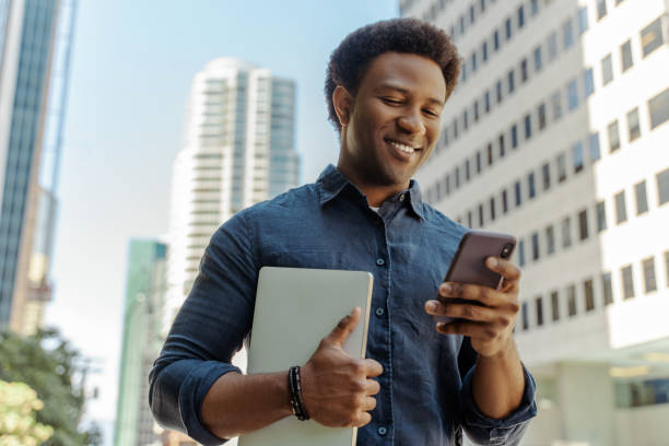 istock Young professional smiling while reading a text message in the city 2181975274