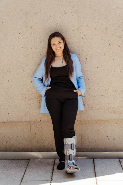 istock Businesswoman with walking boot posing near wall 2181975365