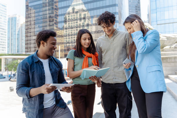 istock Group of young professionals collaborating outdoors on a project using digital tablet and notebook 2181976083