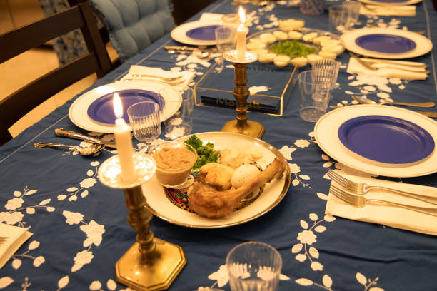 Table Set For Traditional Passover Meal and Sedar Table has been set in Jewish traditional colors of blue and gold for a Passover seder. Seder plate with the symbols of Passover is in the center of the table. passover celebration stock pictures, royalty-free photos & images