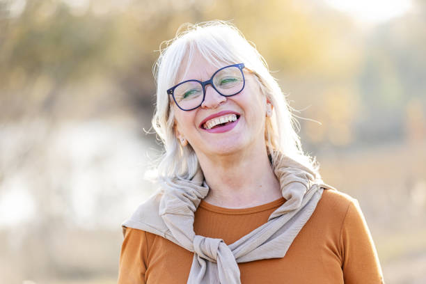 istock Happy Senior Woman Smiling Outdoors in Autumn Sunlight 2181978306