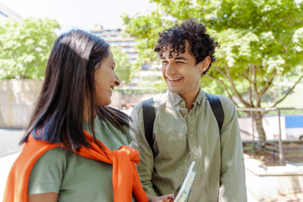 istock Two students walking and talking together outdoors 2181981028