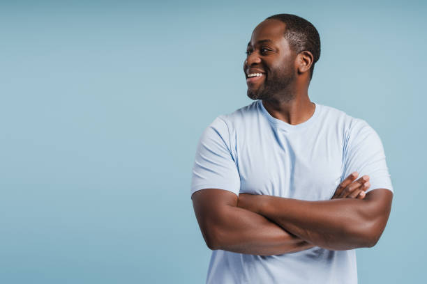 istock Happy African American man looking to copy space in studio, with folded hands 2181982988