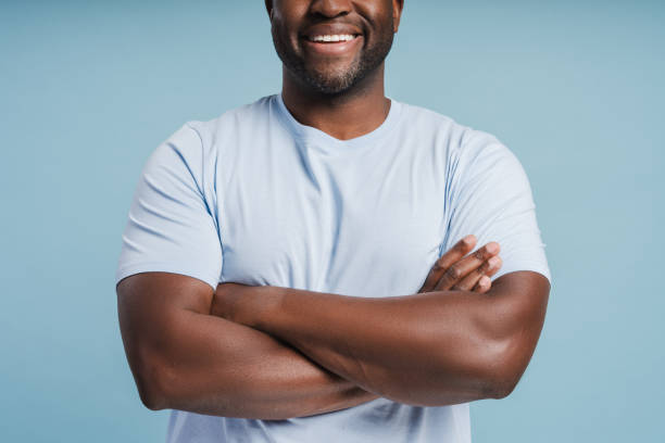 istock Close up of smiling African American man posing with folded hands in studio 2181982990