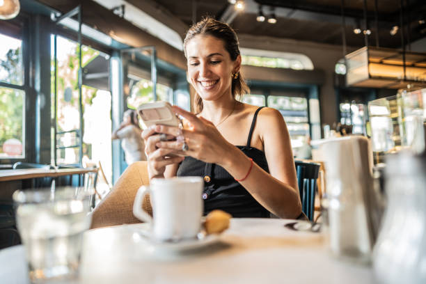 istock Young woman using mobile phone on a coffee shop 2181984429