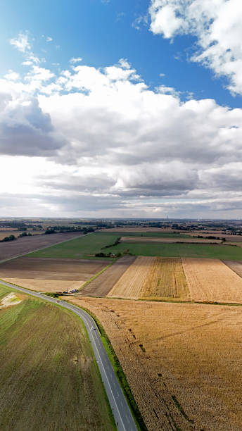 istock Countryside Road Passing through Farmland under a Broad Cloudy Sky 2181984760
