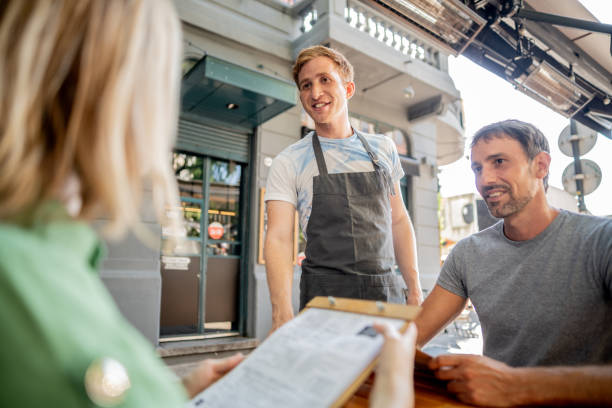 istock Waiter talking with customers on a sidewalk cafe 2181984882
