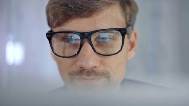 istock Businessman with glasses looking intently obscured partially by a translucent surface of laptop. Business concept 2181988742