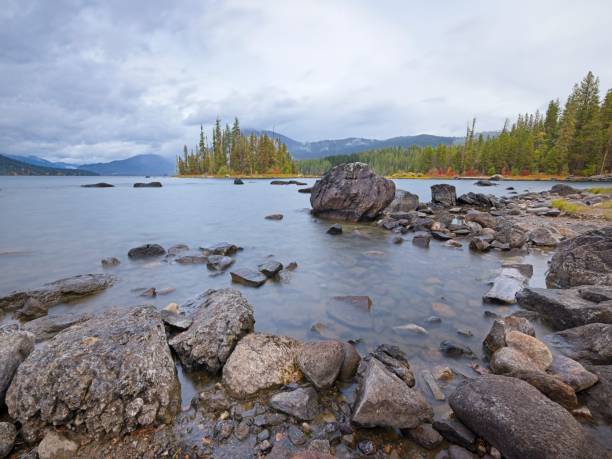 Rocks along the shoreline of Lake Wenatchee under dark cloudy skies.