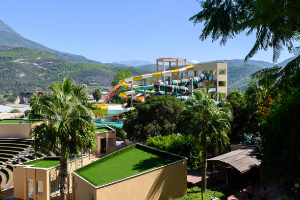 istock A vibrant water park filled with slides and palm trees under a clear blue sky in a picturesque mountainous setting 2181989749