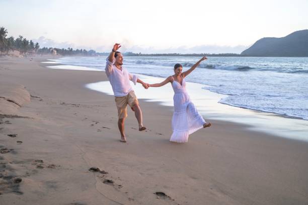 istock Couple expecting a baby at the beach 2181994360