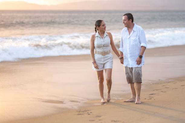 istock A married couple walking on the beach 2181994988