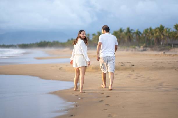 istock A married couple walking on the beach 2181995047