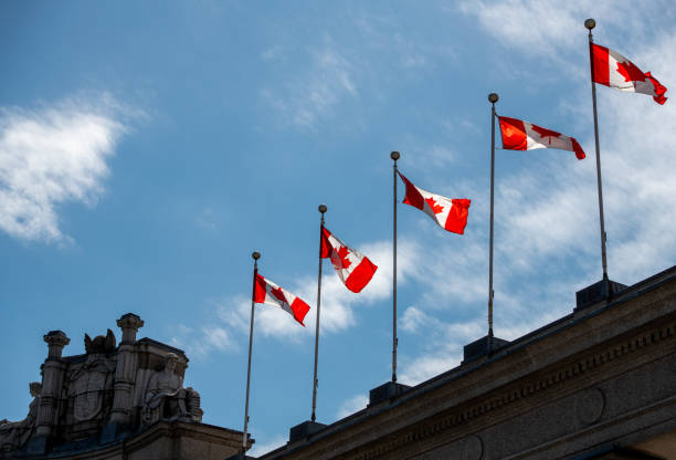 Canadian flags on top of building with blue sky