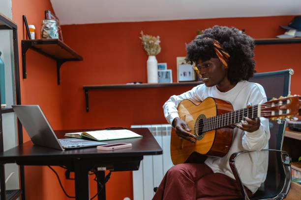 istock Young woman learning guitar through online classes at home 2182002067