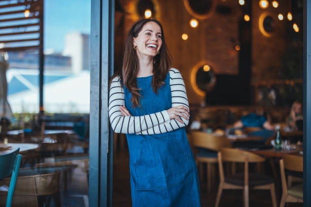 istock Smiling Woman Standing in a Modern Cafe Interior 2182007783