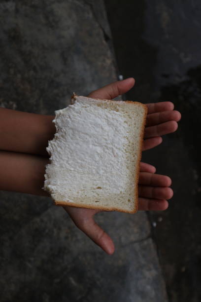 istock a child is eating bread while holding it in his hand 2182010191