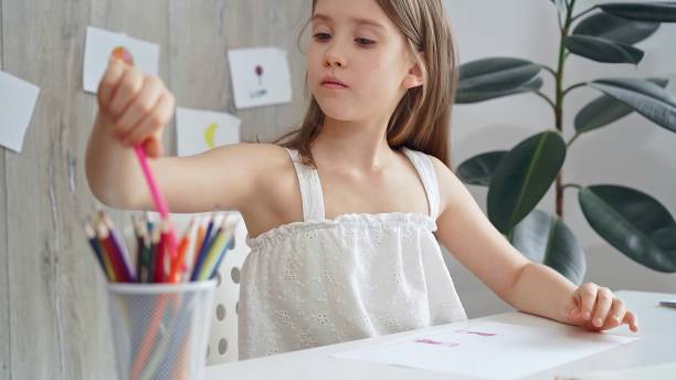istock Young girl choosing colored pencils and picking a pencil from a 2182010259