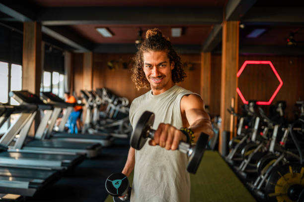 istock Focused Hispanic Man Lifting Weights In Gym 2182011195